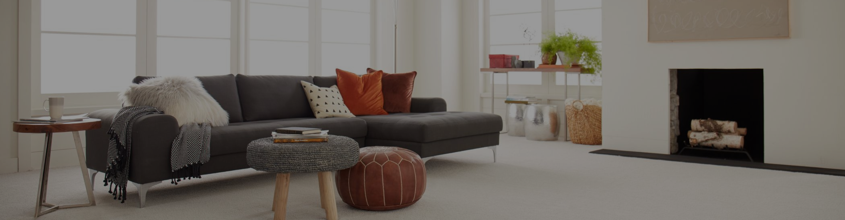 Living room with brown couch and two chairs, beige carpet