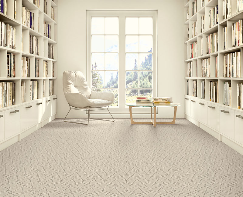 cream patterned carpet in reading room with chair and books